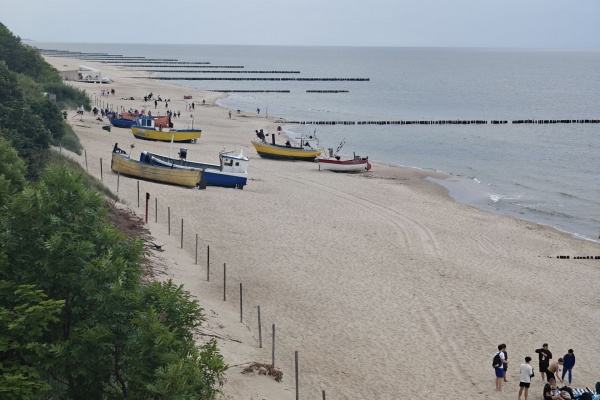 Zdjęcie 2024 rok: Spokojna plaża z łodziami rybackimi na piasku w Rewalu.