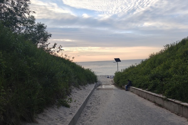 Zachód słońca oglądany z zejścia na plażę.